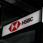 A close-up of a backlit HSBC logo sign on a modern building exterior.